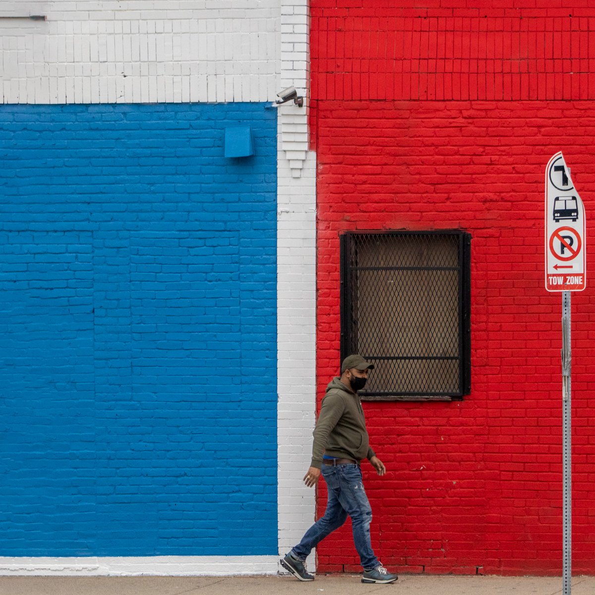 Person walking past a red, white, and blue wall